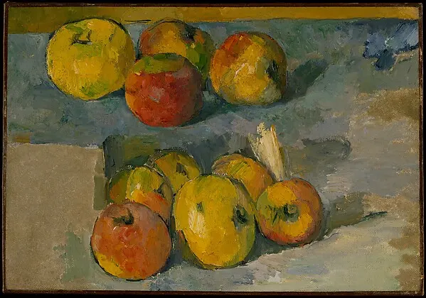Red and yellow apples on a table against a grey-blue wall