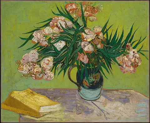 Pink oleander flowers in a pitcher against a bright yellow-green wall