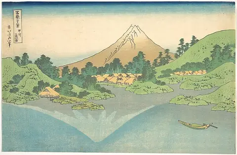 Mount Fuji and green hills reflected in a turquoise lake
