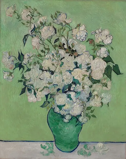 White roses in a green vase against a green background