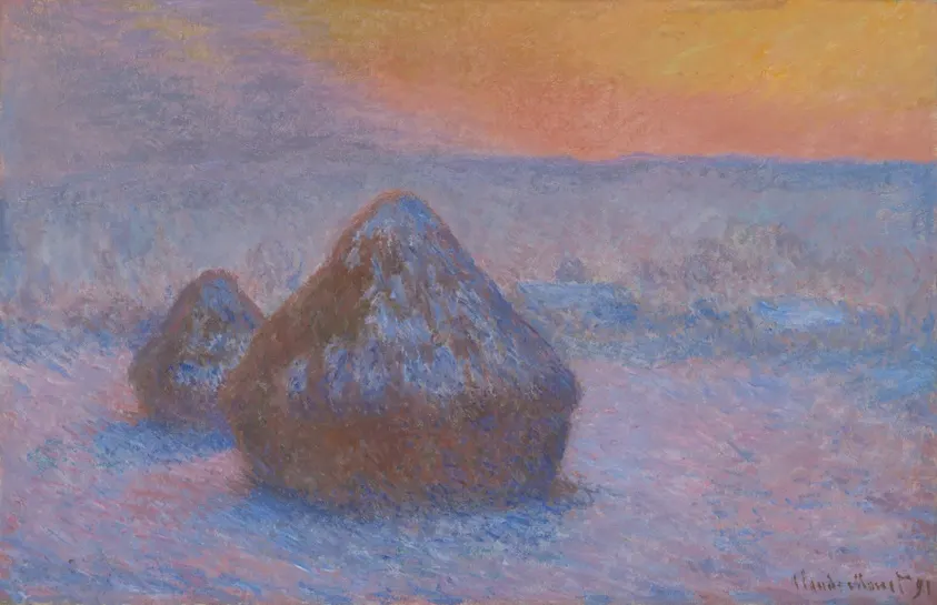 Two haystacks glowing orange against a blue snow-covered field