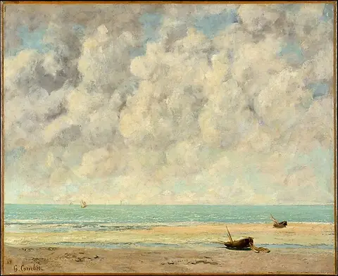 A large cloudy sky over a flat sea and sandy beach with a small boat