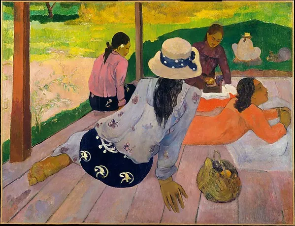 Tahitian women sitting on a porch in pink, orange and blue clothing above green grass