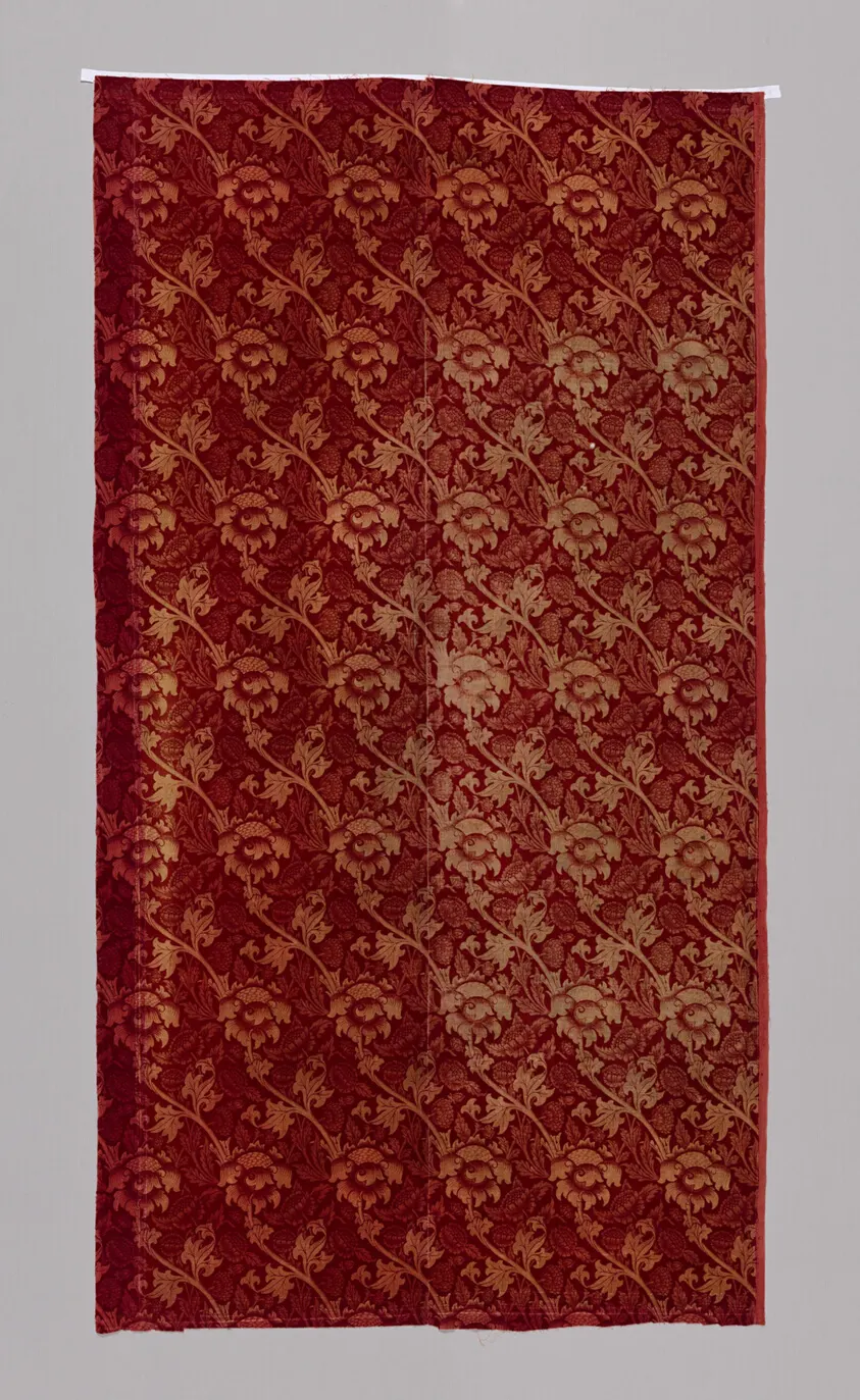 An all-over floral and vine pattern in blue-green and rust
