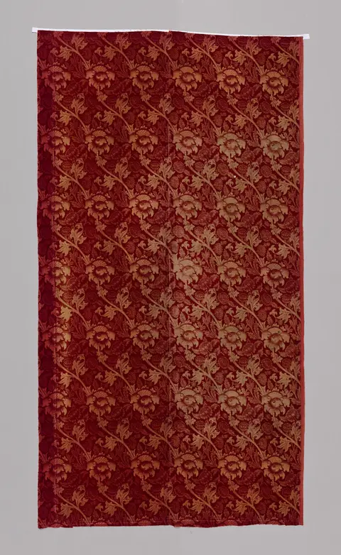 An all-over floral and vine pattern in blue-green and rust